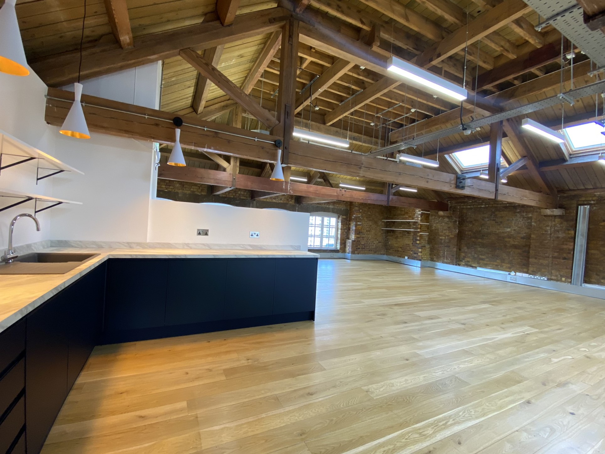 Cat A grade office space with wooden beams and navy marble-top kitchenette